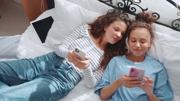 Fröhlich Reden Und Tippen Zwei Frauen Auf Mobiltelefonen Heimischen Bett — Stockvideo