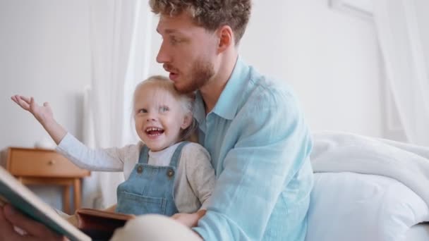 Glückliche Blonde Vater Und Tochter Lesen Buch Hause — Stockvideo