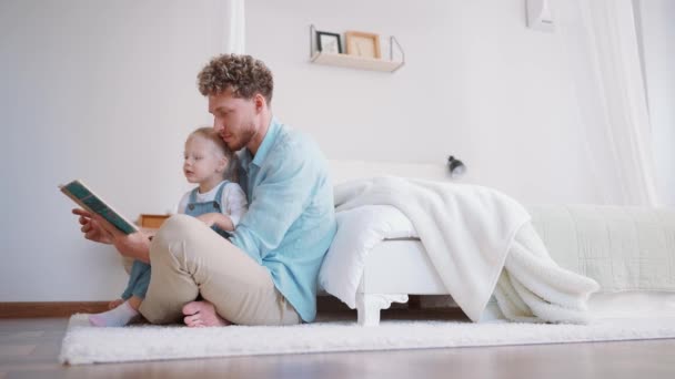 Χαριτωμένος Πατέρας Και Κόρη Ανάγνωση Βιβλίο Στο Πάτωμα Του Σπιτιού — Αρχείο Βίντεο