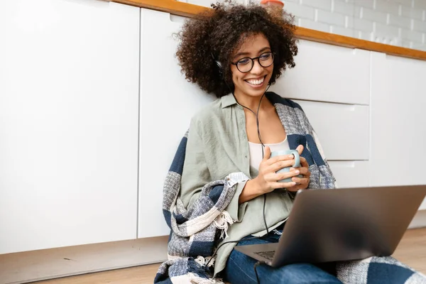 非洲裔美国妇女 头发卷曲 喜欢喝咖啡 在家使用笔记本电脑 — 图库照片