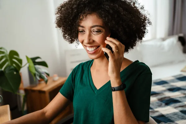 African American Young Woman Curly Hairstyle Smiling Talking Cellphone Home — Stock Photo, Image