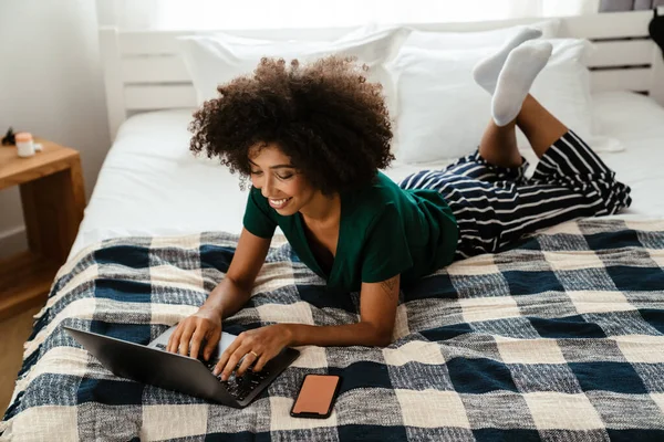 Afrikai Amerikai Fiatal Göndör Frizura Fekszik Ágyban Használja Laptop Otthon — Stock Fotó