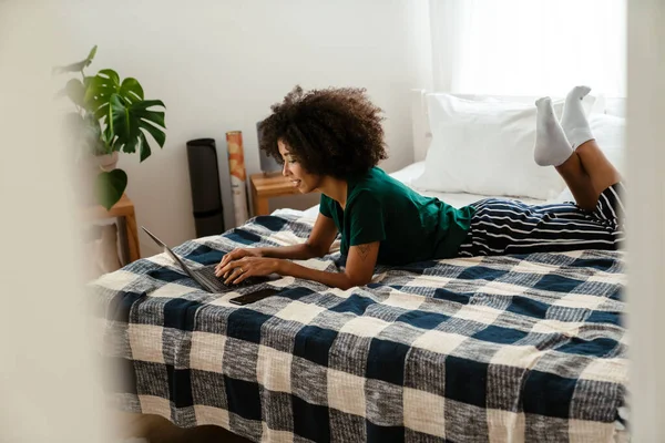 Afrikai Amerikai Fiatal Göndör Frizura Fekszik Ágyban Használja Laptop Otthon — Stock Fotó