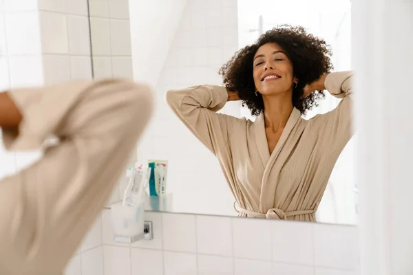 Kıvırcık Saçlı Gülümseyen Aynaya Bakan Afro Amerikan Genç Kadın — Stok fotoğraf