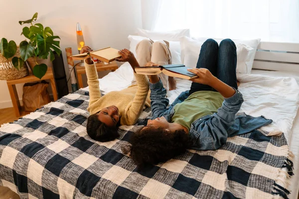 Black Girl Her Mother Laughing Reading Books While Lying Bed — Stock Photo, Image