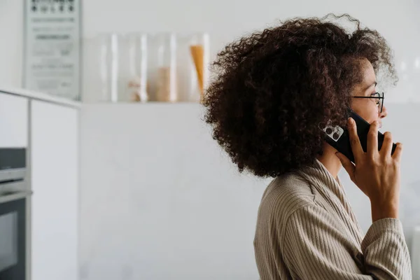 非洲裔美国妇女 头发卷曲 在家里用手机交谈 — 图库照片