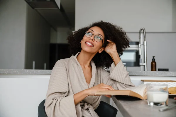 Black Woman Wearing Eyeglasses Reading Book While Having Breakfast Home — Stock Photo, Image