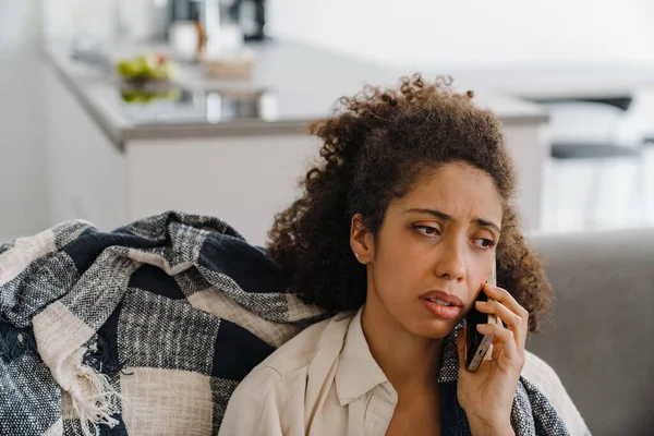 Черная Недовольная Женщина Разговаривает Мобильному Телефону Сидя Дома Диване — стоковое фото