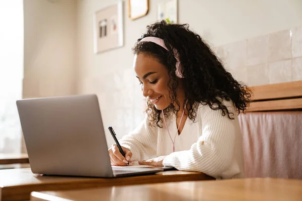 Joven Mujer Negra Escribiendo Notas Mientras Trabaja Con Ordenador Portátil — Foto de Stock