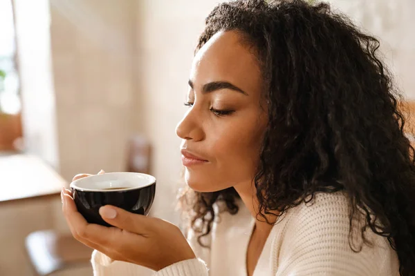 Młoda Czarna Kobieta Pije Kawę Siedząc Kawiarni — Zdjęcie stockowe