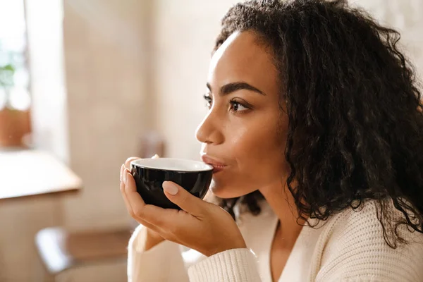 Młoda Czarna Kobieta Pije Kawę Siedząc Kawiarni — Zdjęcie stockowe