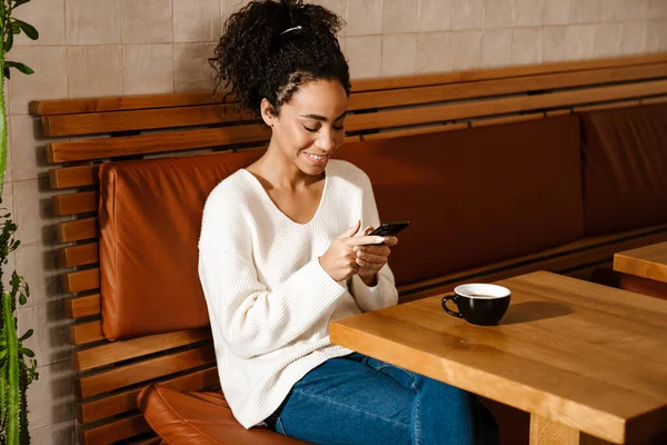 Joven Mujer Negra Usando Teléfono Móvil Mientras Bebe Café Café —  Fotos de Stock