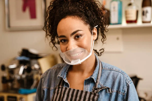 Kapalı Bir Kafede Çalışırken Gülümseyen Yüz Maskesi Takan Siyahi Kadın — Stok fotoğraf