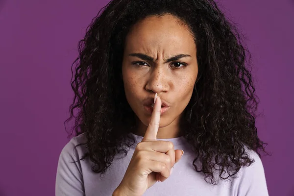 stock image Young black woman frowning while making silence gesture isolated over purple background