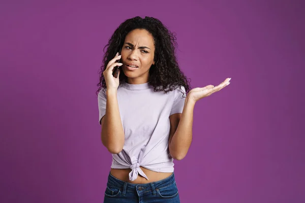 年轻的黑人妇女用手机说话 带着用紫色背景隔开的盗版空间 — 图库照片