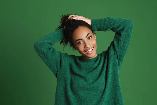 Молодая Черная Женщина Смеется Держа Волосы Изолированы Зеленом Фоне — стоковое фото