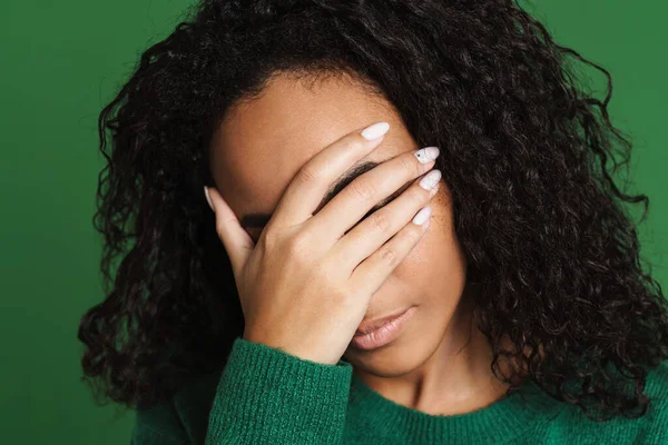 stock image Young black woman with wavy hair covering her face isolated over green background