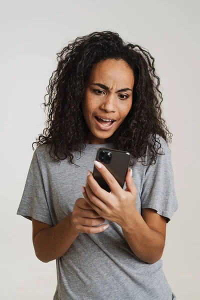 Young Black Woman Using Mobile Phone Expressing Surprise Isolated White — Stock Photo, Image
