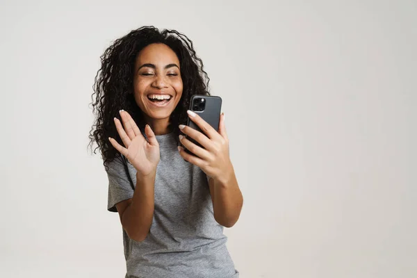 Joven Mujer Negra Usando Teléfono Celular Haciendo Gestos Aislados Sobre — Foto de Stock