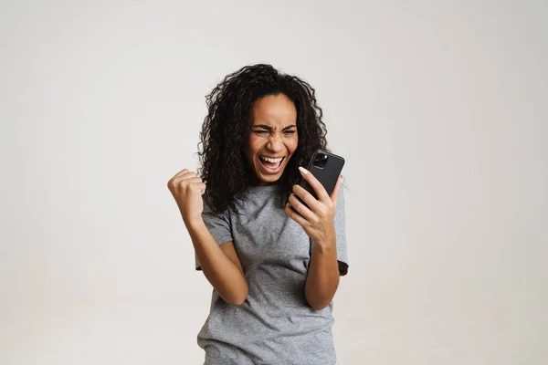 Młody Czarny Kobieta Pomocą Telefon Komórkowy Zwycięzca Gest Izolowane Białym — Zdjęcie stockowe