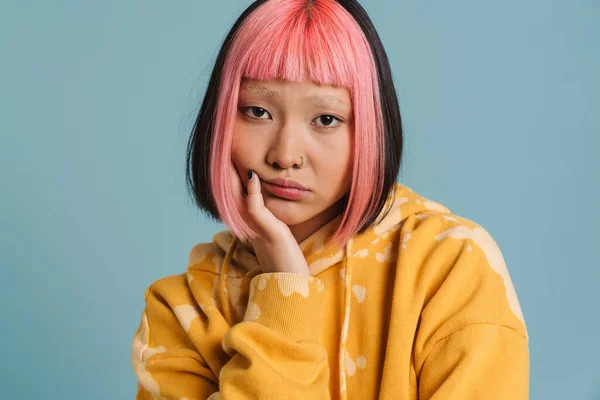 亚洲女孩 一头粉红的头发 皱着眉头 凝视着蓝色背景的相机 — 图库照片