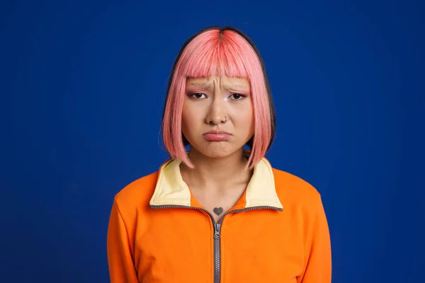 Azji Dziewczyna Różowymi Włosami Przekłuwające Zmarszczki Patrząc Aparat Odizolowany Niebieskim — Zdjęcie stockowe