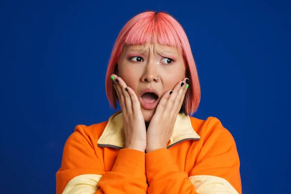 Azji Dziewczyna Różowymi Włosami Piercing Wyrażając Zaskoczenie Aparacie Izolowane Niebieskim — Zdjęcie stockowe