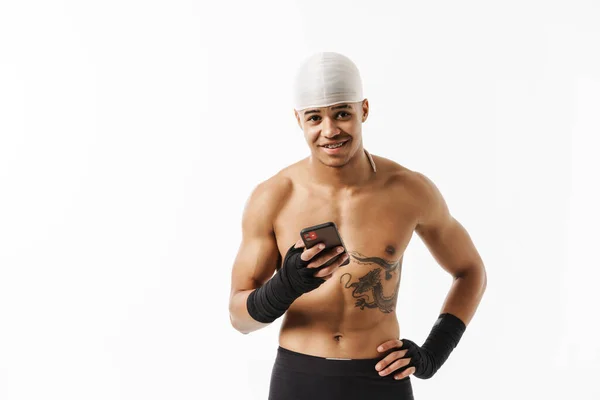 Junger Hemdloser Sportler Lächelt Während Sein Handy Isoliert Auf Weißem — Stockfoto