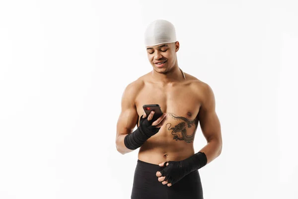 Młody Sportowiec Bez Koszulki Tatuażem Uśmiechnięty Telefonem Komórkowym Odizolowanym Białym — Zdjęcie stockowe