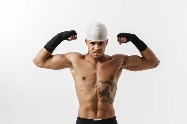 Młody Sportowiec Bez Koszulki Pokazuje Swoje Bicepsy Przed Kamerą Odizolowany — Zdjęcie stockowe