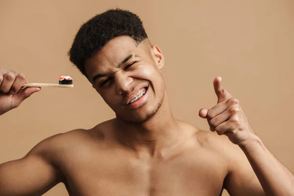 Mladý Muž Bez Košile Ukazuje Prstem Kameru Zatímco Pózuje Kartáčkem — Stock fotografie