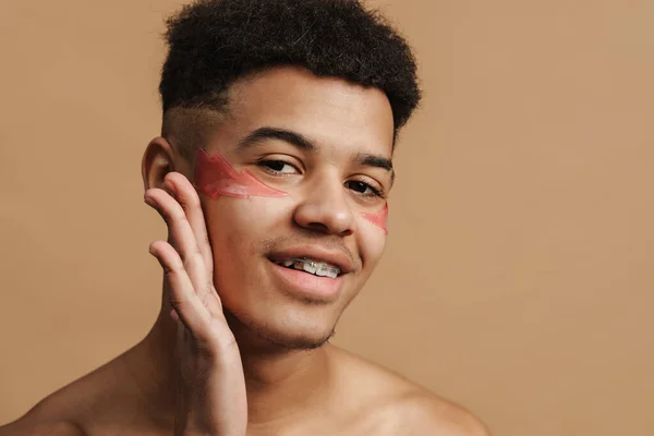 Młody Mężczyzna Bez Koszuli Plastrami Kosmetycznymi Uśmiechnięty Kamery Odizolowany Beżowego — Zdjęcie stockowe