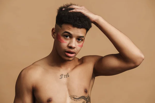 Mladý Muž Bez Košile Skvrnami Drží Hlavu Dívá Kameru Izolované — Stock fotografie