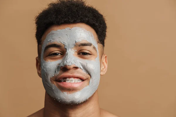 Young Shirtless Man Cosmetic Clay Mask Smiling Camera Isolated Beige — ストック写真