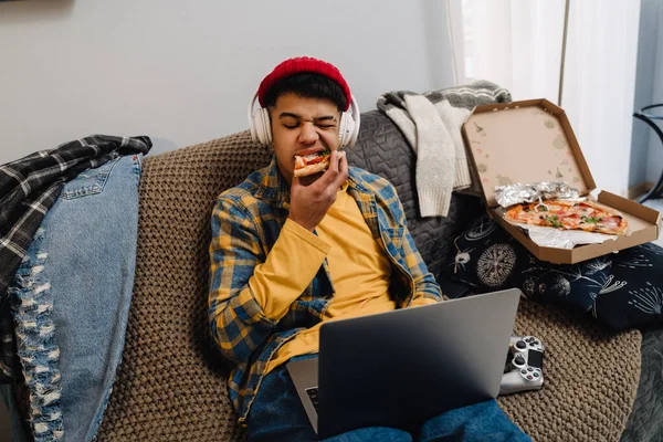 Adolescente Oriente Medio Comiendo Pizza Usando Portátil Mientras Está Sentado —  Fotos de Stock