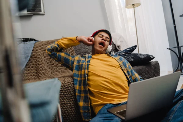 Middle Eastern Teenage Boy Yawning While Using Laptop Sitting Floor — Stock Photo, Image