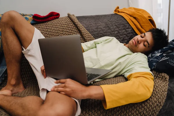 Brünette Teenager Junge Using Laptop Während Liegend Auf Couch Schlafzimmer — Stockfoto