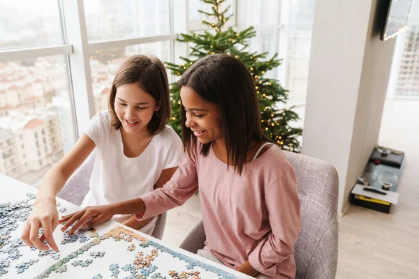 Vielrassige Schwestern Lachen Während Sie Hause Gemeinsam Rätseln — Stockfoto