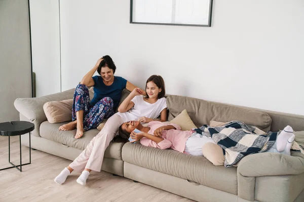 Mujer Blanca Sus Hijas Riendo Mientras Descansan Sofá Casa —  Fotos de Stock