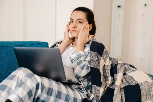 Ung Kvinna Bär Pyjamas Med Bärbar Dator Medan Vilar Soffan — Stockfoto