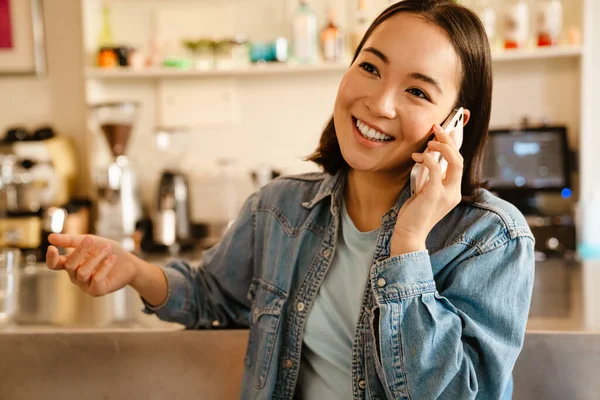Молодая Азиатка Джинсовой Рубашке Улыбается Разговаривает Телефону Кафе — стоковое фото