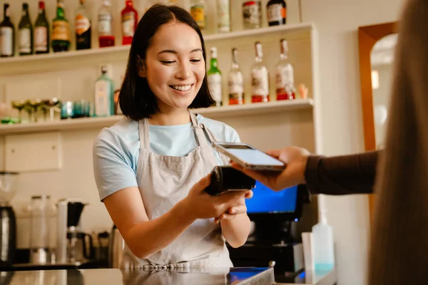 Kafede Müşteriyle Çalışırken Önlük Takan Asyalı Kadın Gülümsüyor — Stok fotoğraf