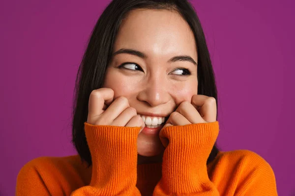 stock image Young asian woman wearing sweater smiling and looking aside isolated over purple background