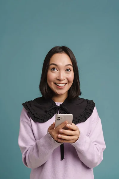 Ung Asiatisk Kvinna Ler Och Använder Mobiltelefon Isolerad Över Blå — Stockfoto