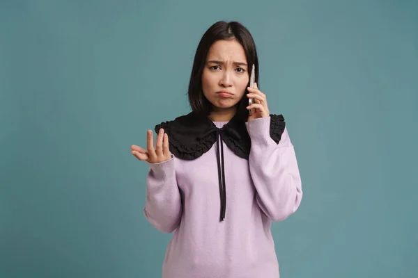 Νεαρή Ασιάτισσα Που Κατσουφιάζει Και Μιλάει Στο Κινητό Τηλέφωνο Απομονωμένη — Φωτογραφία Αρχείου