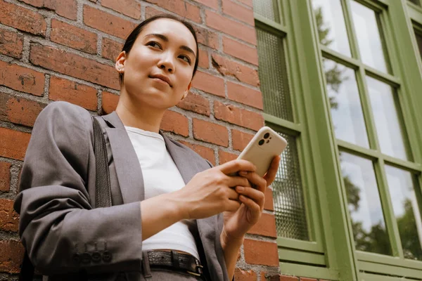 Asiatisk Ung Affärskvinna Som Använder Mobiltelefon Stående Vid Väggen Utomhus — Stockfoto