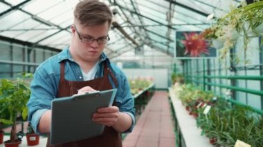 Serada yürüyen ve yazan düşük sendromlu odaklanmış erkek çiçekçi.