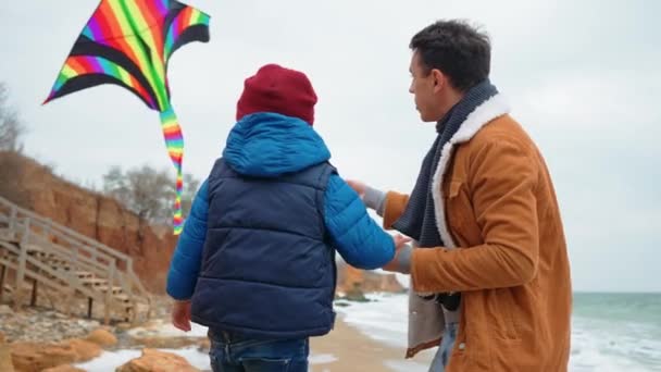 素敵な父親と息子はビーチで海で凧を飛ぶ — ストック動画