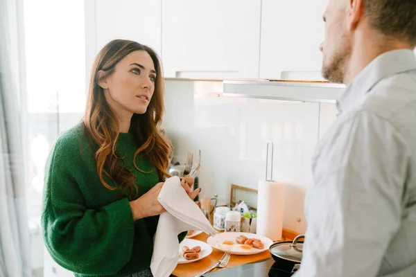 아내가 남편을 바라보고 부엌에서 설거지를 — 스톡 사진