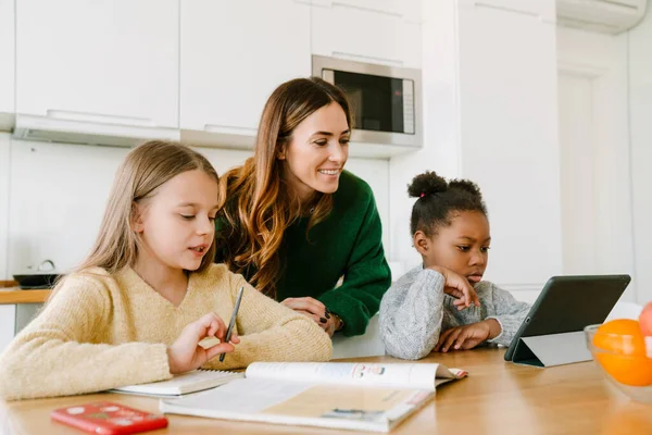 Glücklich Lächelnde Mutter Hilft Ihren Töchtern Bei Den Hausaufgaben Der — Stockfoto